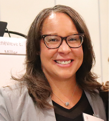 woman with glasses and gray blazer