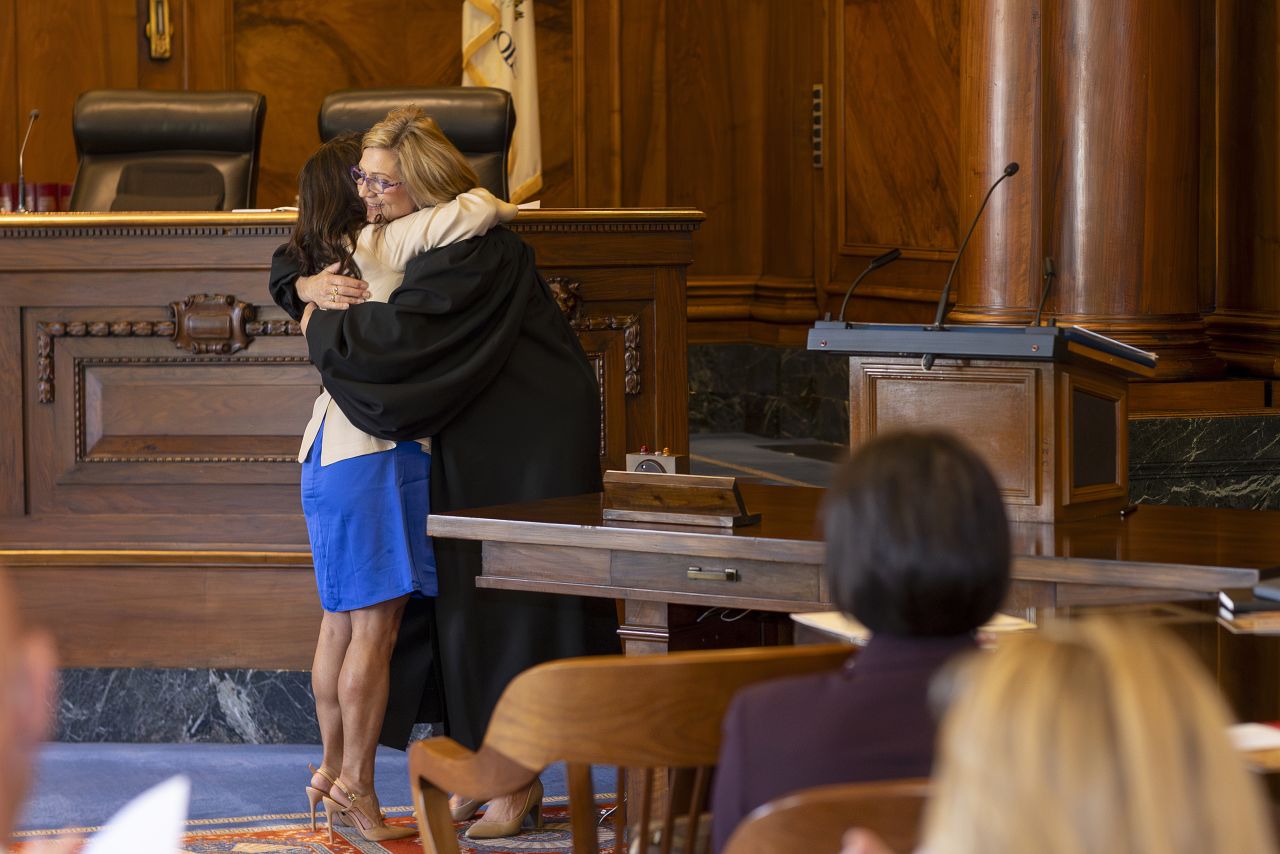 Sonni Choi Williams and Justice Mark K. O'Brien embrace following Williams taking the oath.